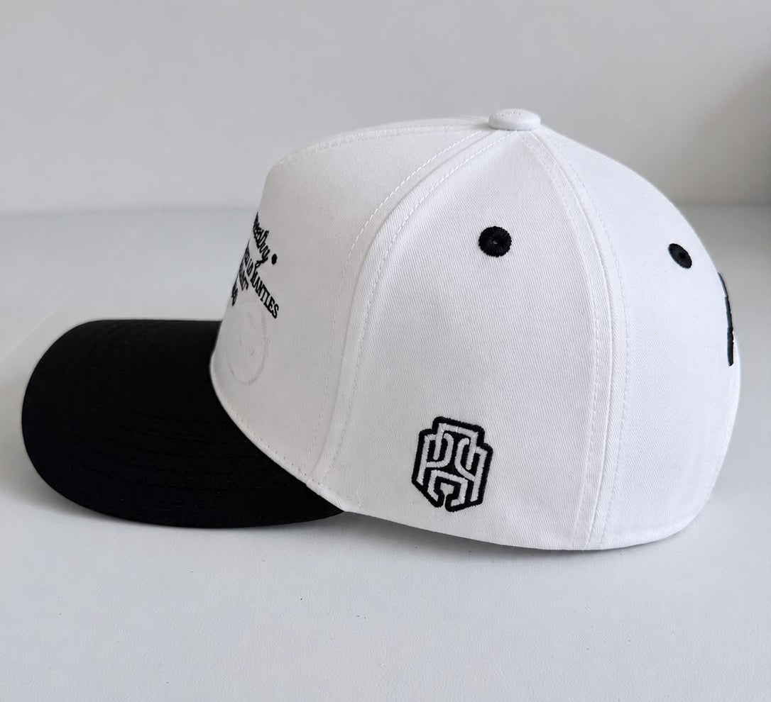 Vista lateral de gorra AP Crown blanca con visera negra y bordado lateral