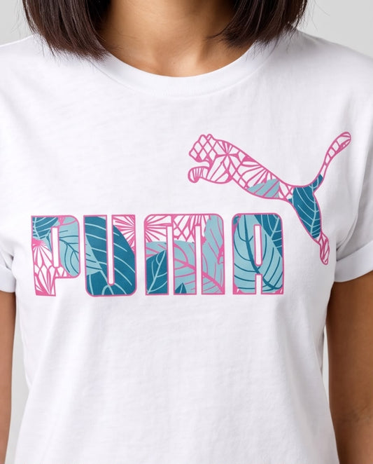 Camiseta blanca Puma con logo tropical rosa y azul, modelo en exterior