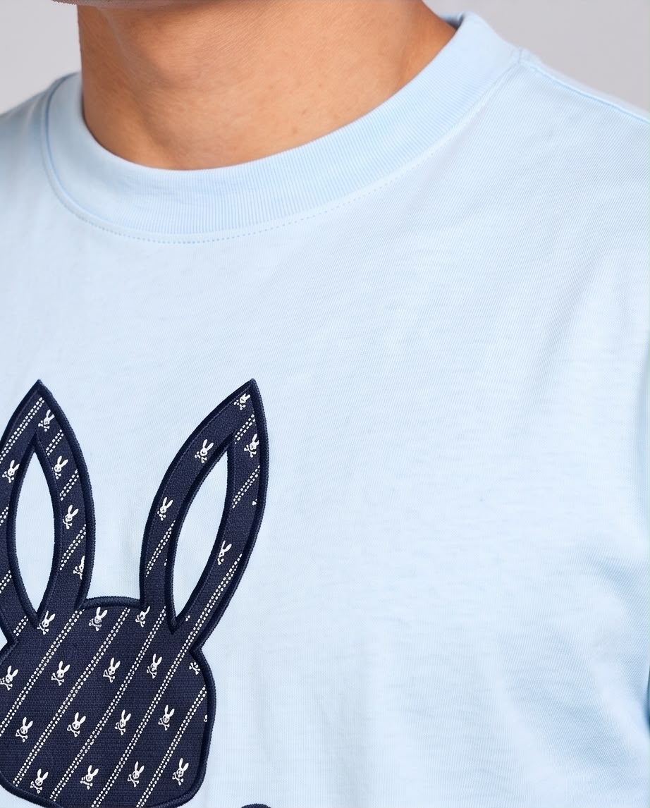 Detalle del estampado de conejo con monograma y líneas diagonales