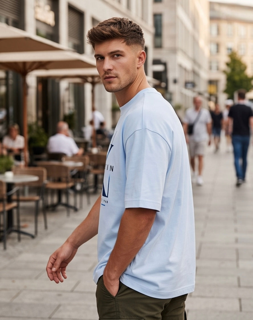 Camiseta Calvin Klein CK New York Est. 1968 Blue Gradient Azul Cielo - Lifestyle modelo caminando calle terraza cafetería