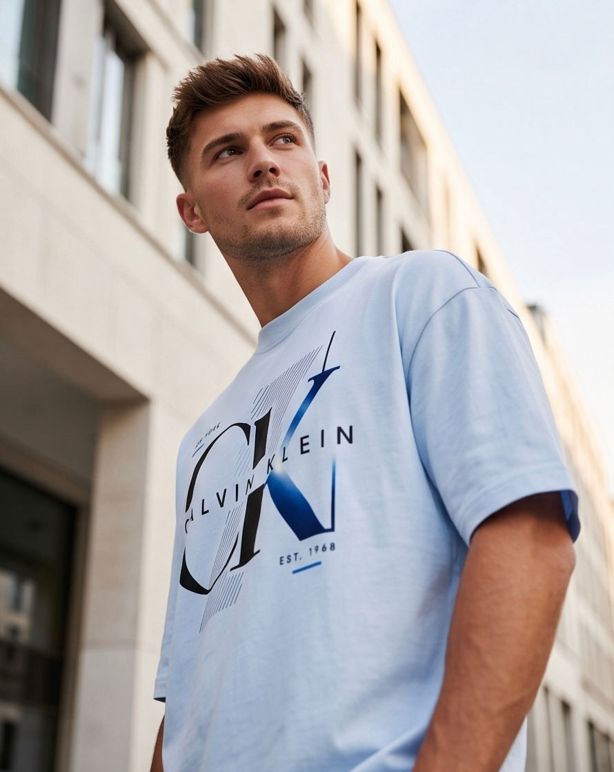 Camiseta Calvin Klein CK New York Est. 1968 Blue Gradient Azul Cielo - Lifestyle modelo vista lateral caminando calle edificios