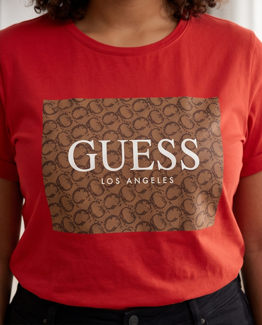 Detalle close up caja monograma Guess Los Angeles camel sobre rojo