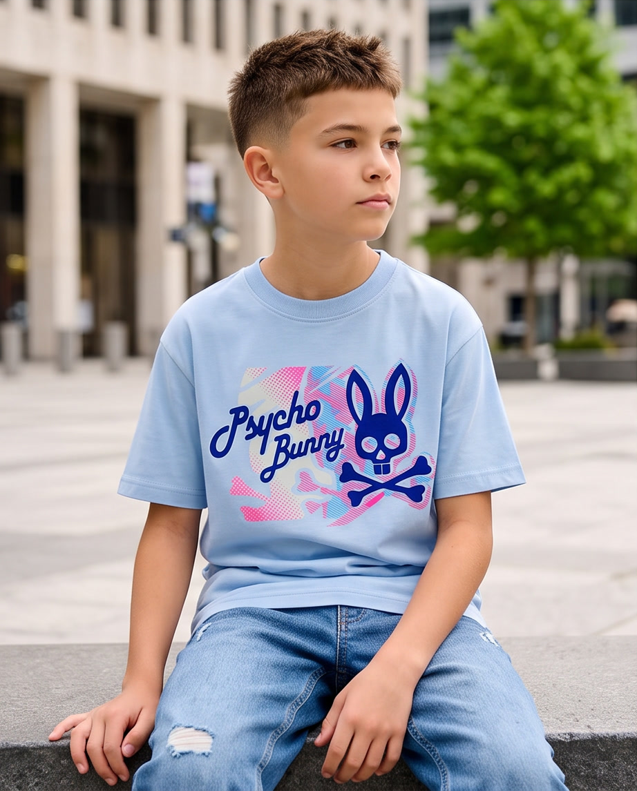 Camiseta Psycho Bunny Camo Halftone Script Azul Cielo Niños - modelo sentado plaza