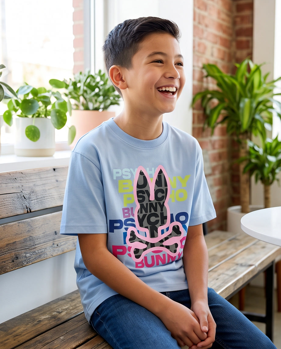 Camiseta Psycho Bunny Multicolor Wordmark Fill Azul Cielo Niños - modelo sentado riendo