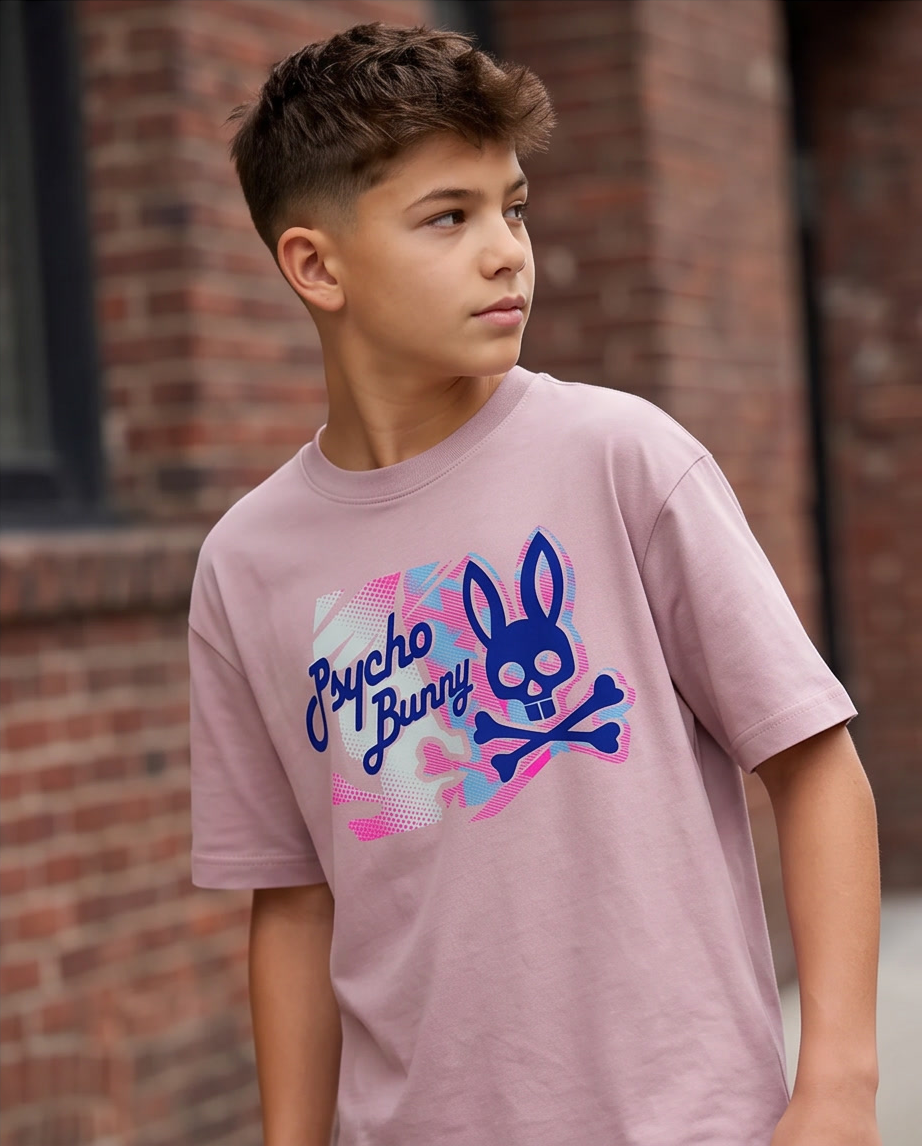 Camiseta Psycho Bunny Camo Halftone Script Rosa Palo Niños - modelo cuerpo completo fondo blanco