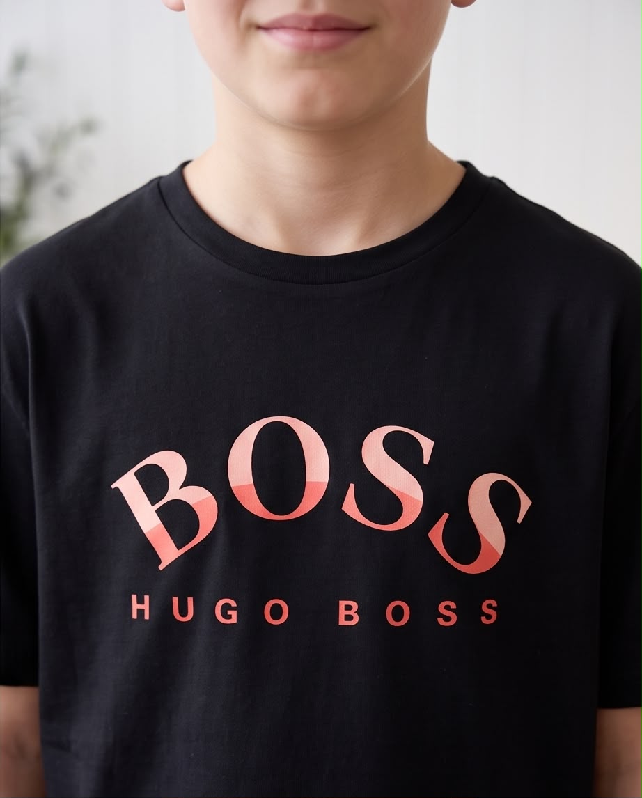 Camiseta Hugo Boss Niños BOSS Arch Coral Negro - Flat lay producto doblado con etiqueta madera