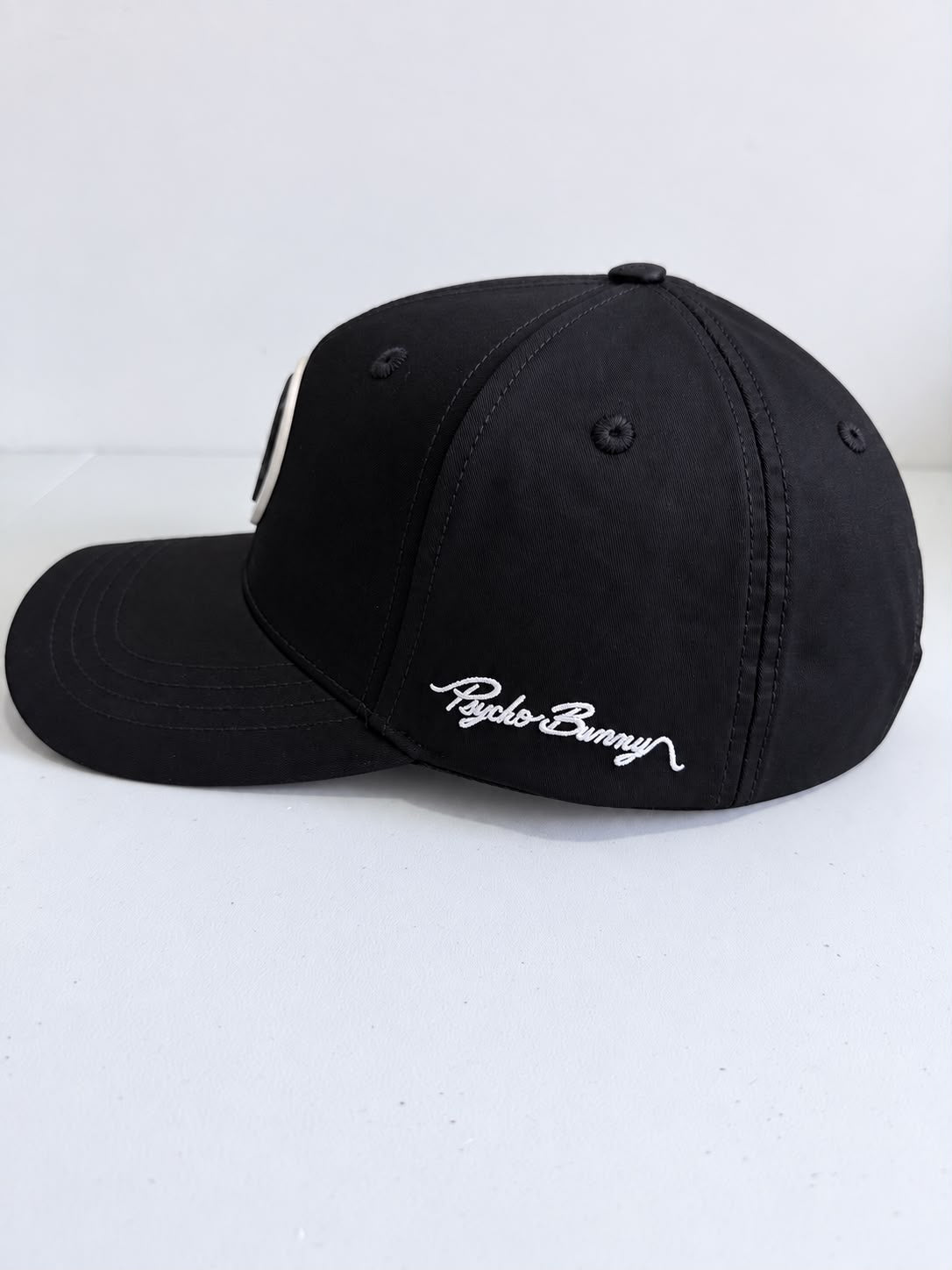Gorra Psycho Bunny negra vista lateral