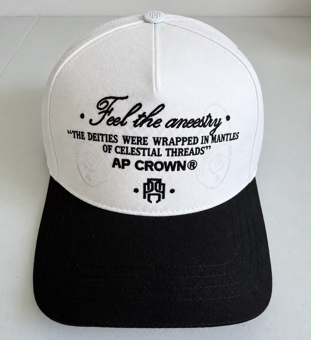 Gorra AP Crown blanca con visera negra y bordado Feel the ancestry, vista frontal