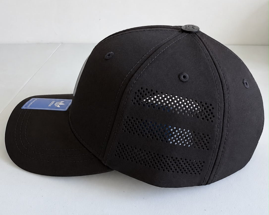 Vista lateral de gorra Adidas negra con paneles perforados