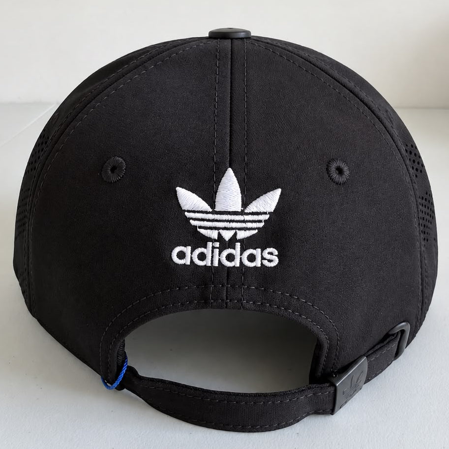 Vista frontal de gorra Adidas negra con parche circular Trefoil blanco y negro