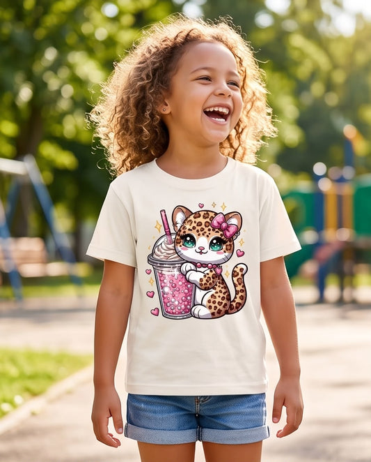 Niña con camiseta Vainilla de gatita de manchas y bebida rosa, vista frontal
