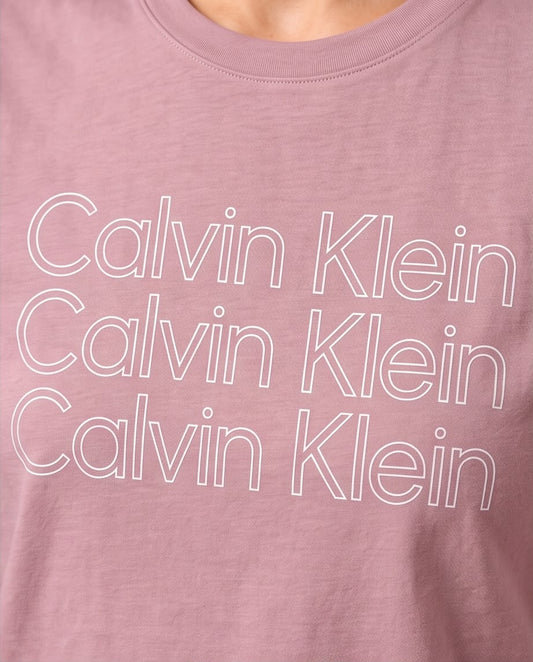 Detalle del estampado Calvin Klein repetido en camiseta rosa empolvado