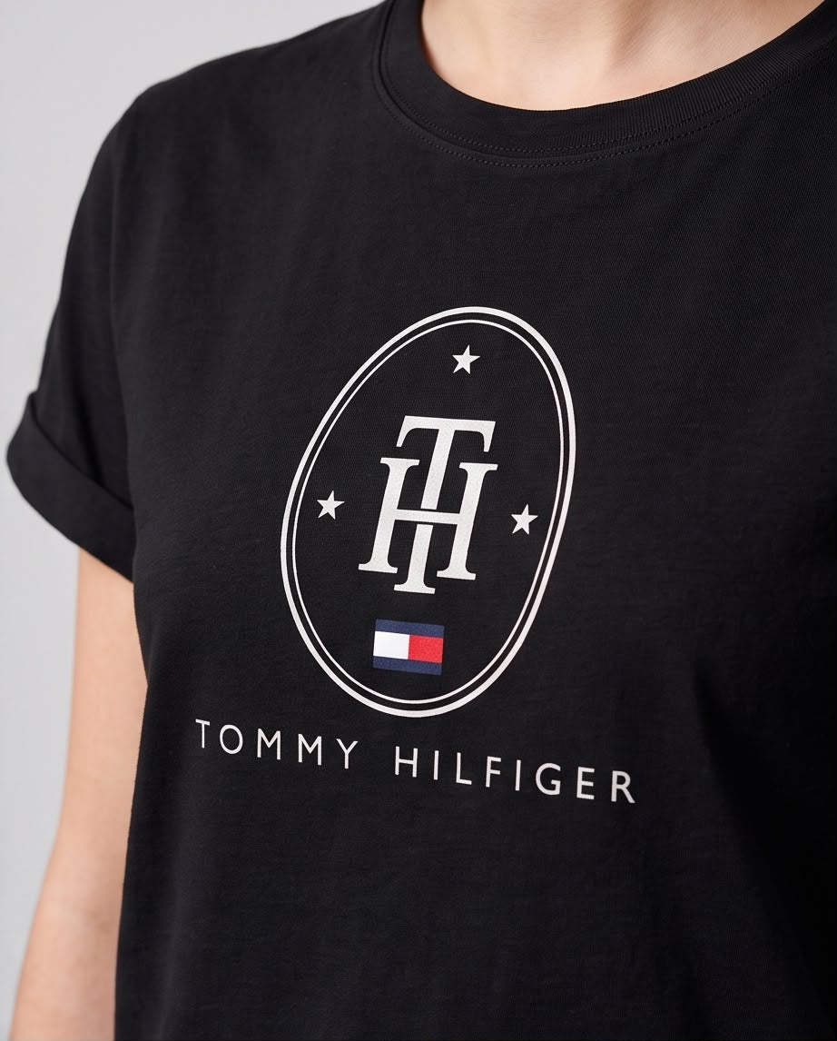 Detalle del emblema ovalado TH con estrellas y bandera Tommy Hilfiger