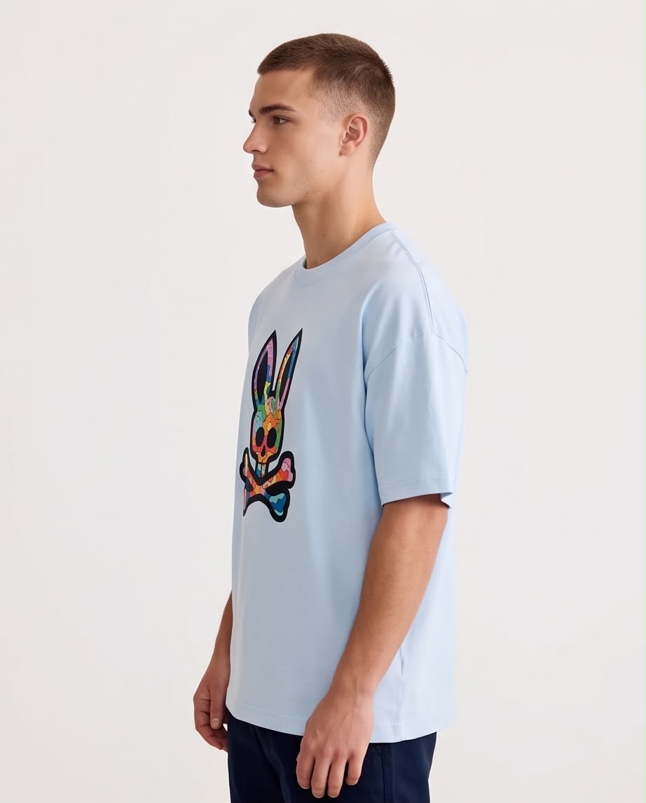 Camiseta azul claro con calavera de conejo multicolor, modelo sentado