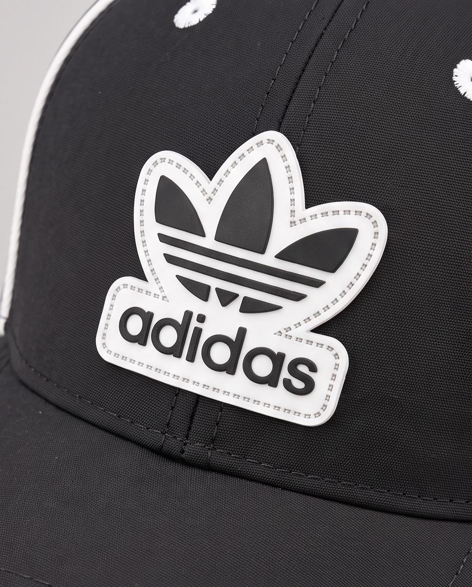 Detalle del parche frontal blanco y negro Adidas Trefoil