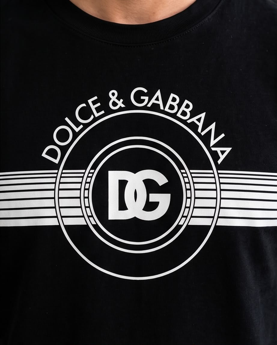 Camiseta negra con emblema DG circular y franjas blancas, vista frontal