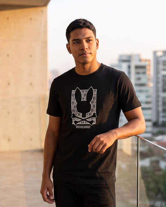 Camiseta negra Psycho Bunny monograma blanco, modelo en balcón