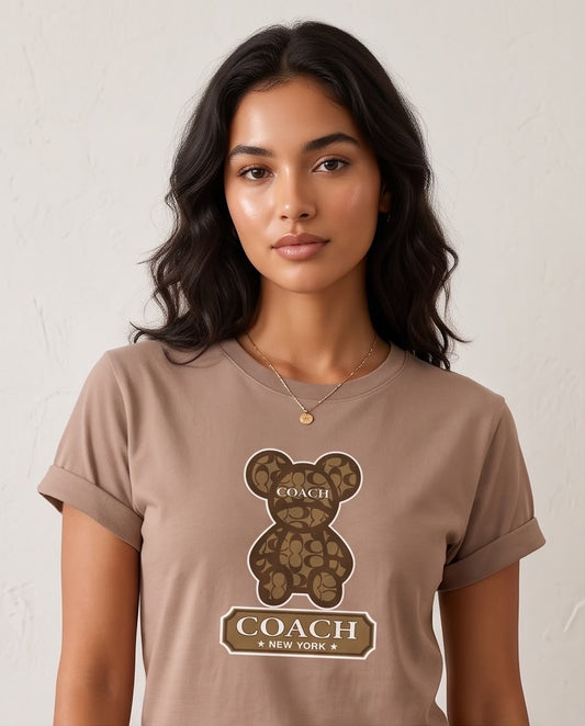 Detalle del oso de monogramas café y letras Coach New York