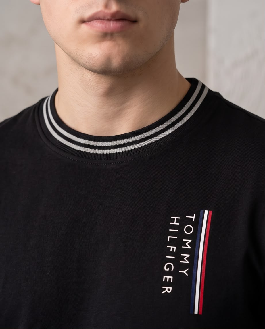 Detalle del logo vertical Tommy Hilfiger, franja tricolor y cuello de rayas