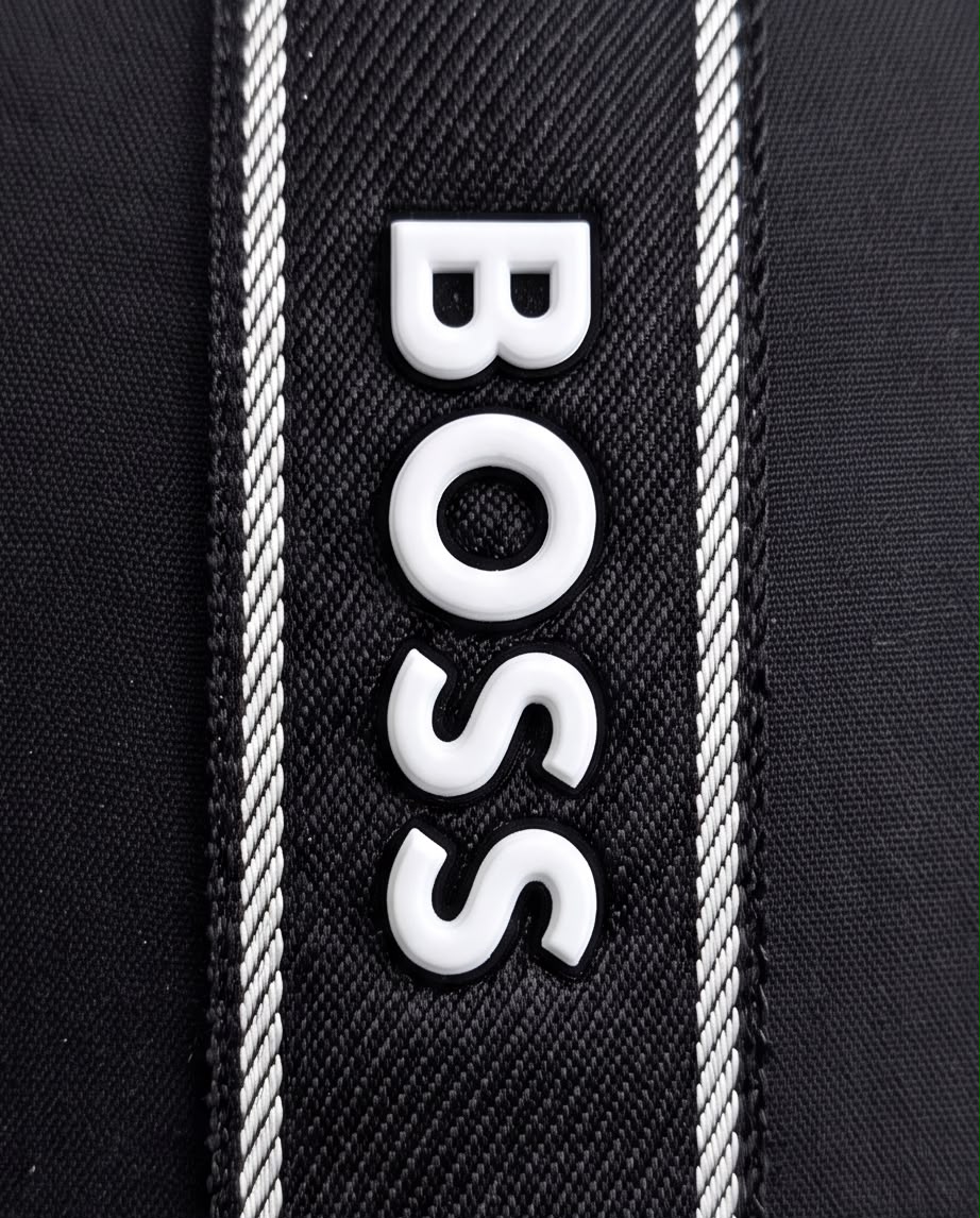 Detalle de letras BOSS blancas en relieve sobre franja negra