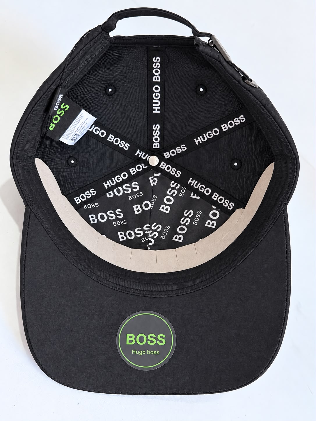 Vista posterior de gorra negra con emblema y correa ajustable