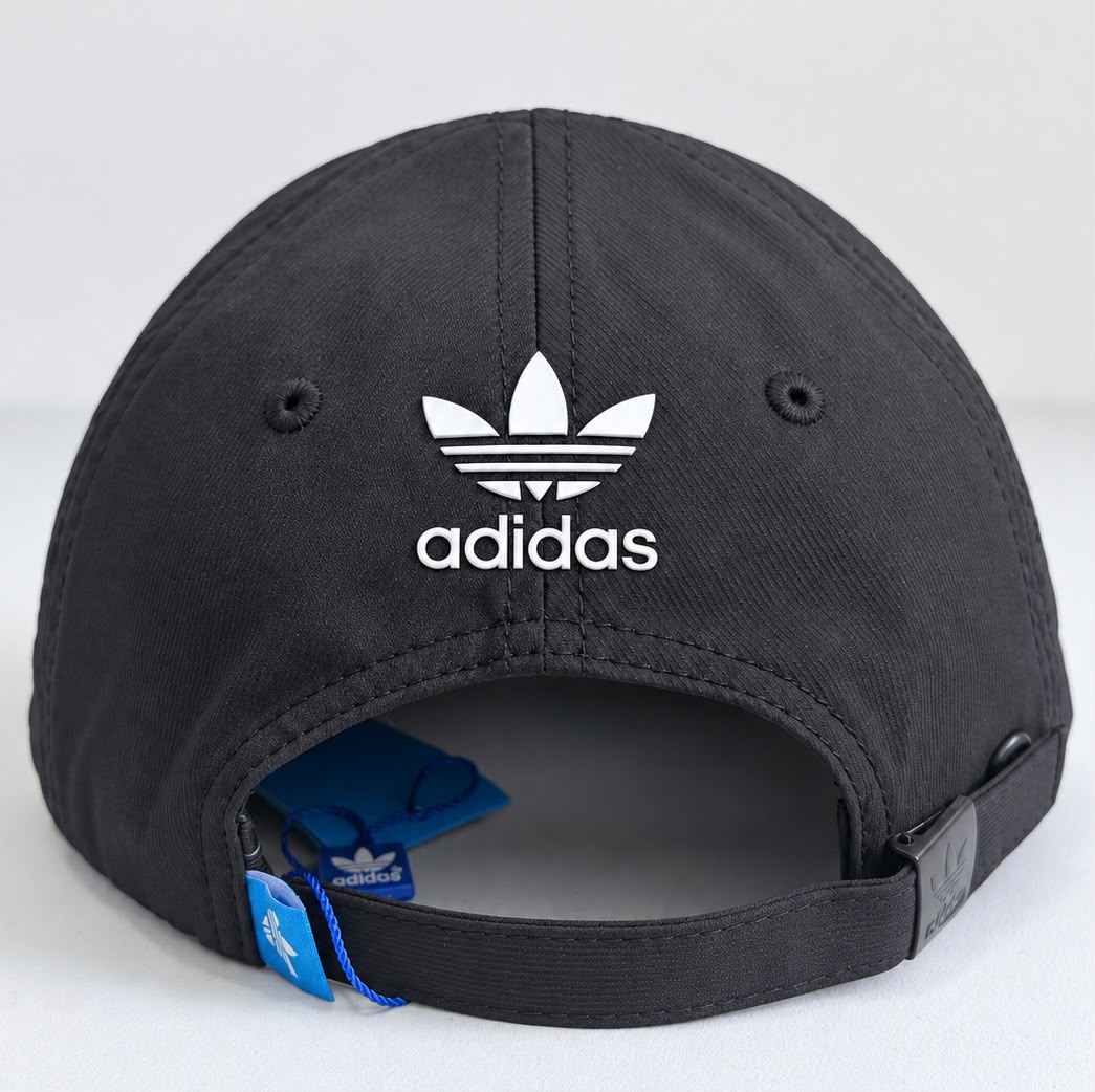 Gorra Adidas negra con bordado blanco de trébol y laureles, vista frontal