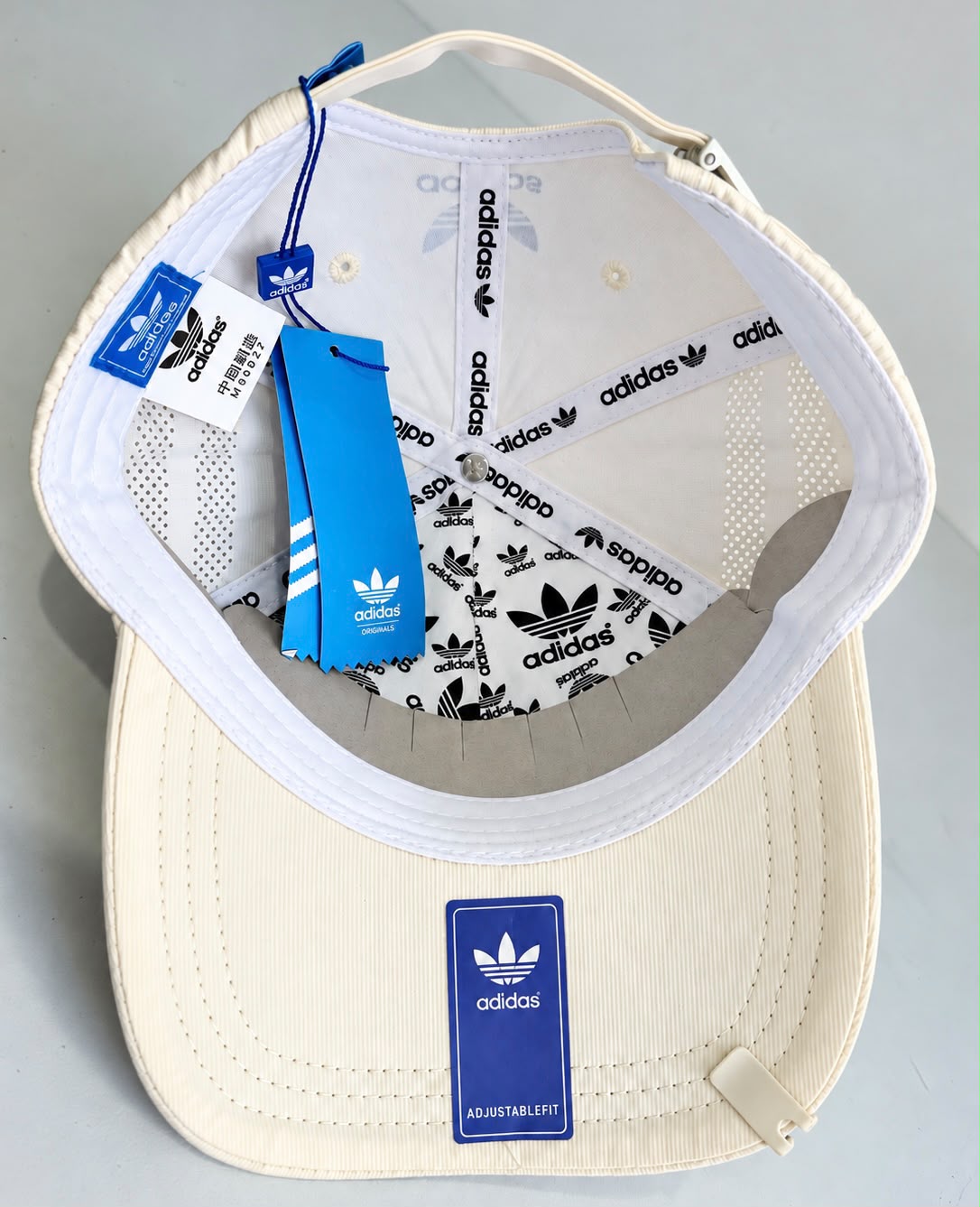 Gorra crema con trébol y laureles negros, vista frontal