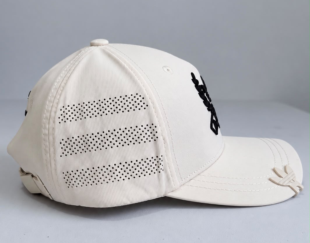 Vista lateral de gorra crema con tres franjas perforadas