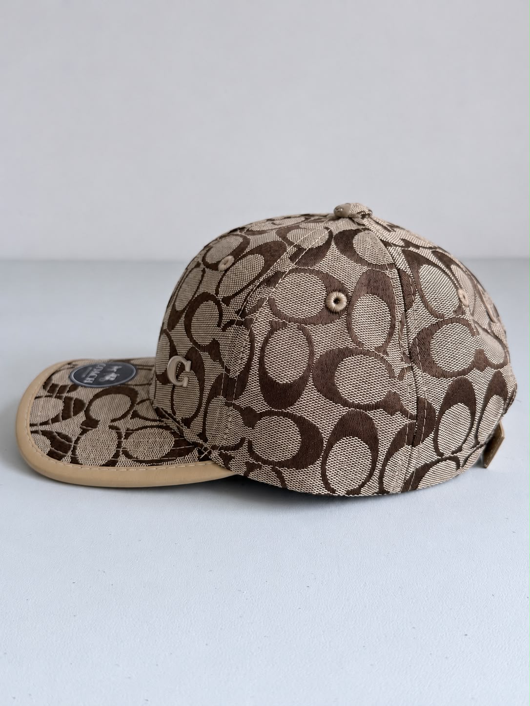 Gorra Coach monograma beige con café, vista trasera con correa ajustable