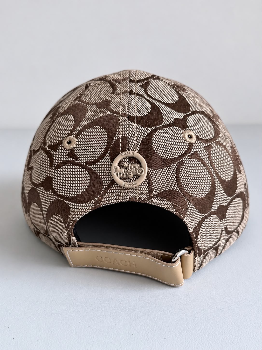 Interior de gorra Coach monograma beige con café y parte inferior de la visera